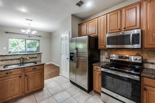 kitchen featuring decorative backsplash, stainless steel appliances, sink, an inviting chandelier, and light tile patterned floors