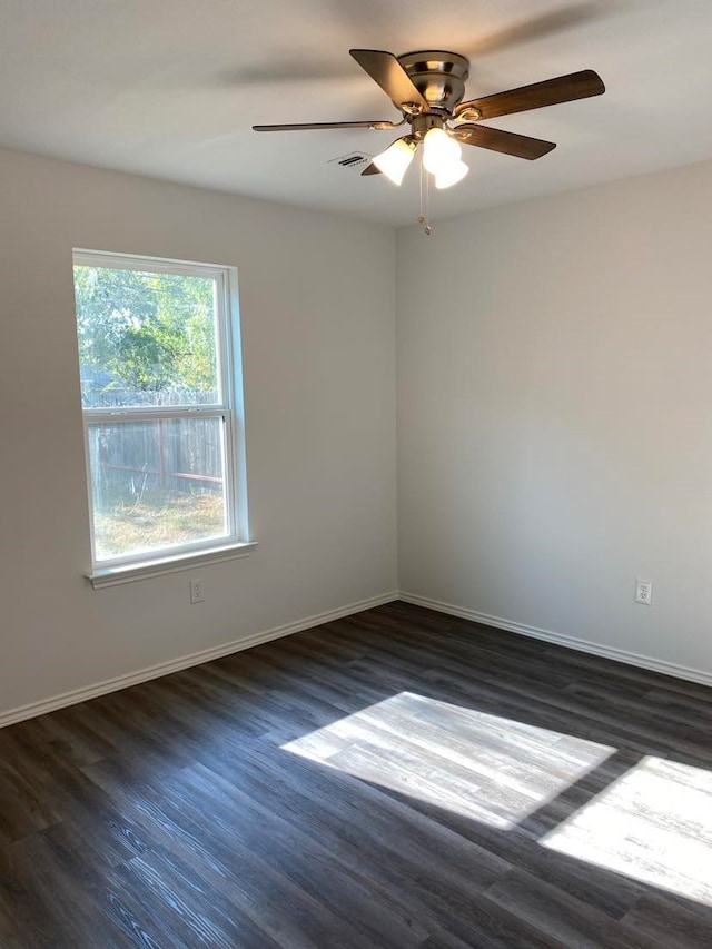 spare room featuring dark wood-type flooring and ceiling fan