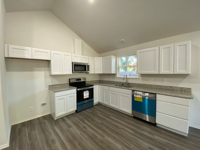 kitchen with dark wood-type flooring, stainless steel appliances, sink, white cabinetry, and high vaulted ceiling