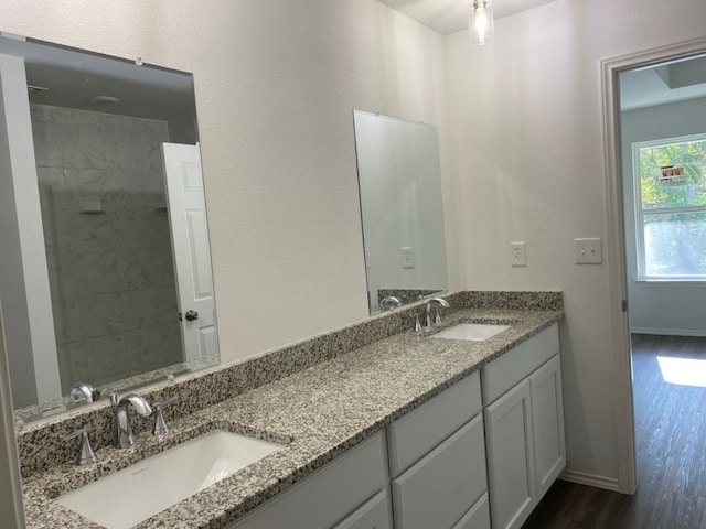 bathroom featuring vanity, wood-type flooring, and tiled shower