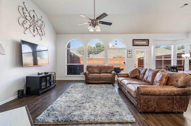 living room featuring lofted ceiling, dark wood-type flooring, a wood stove, and ceiling fan