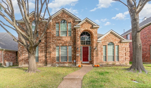 traditional home with a front lawn and brick siding