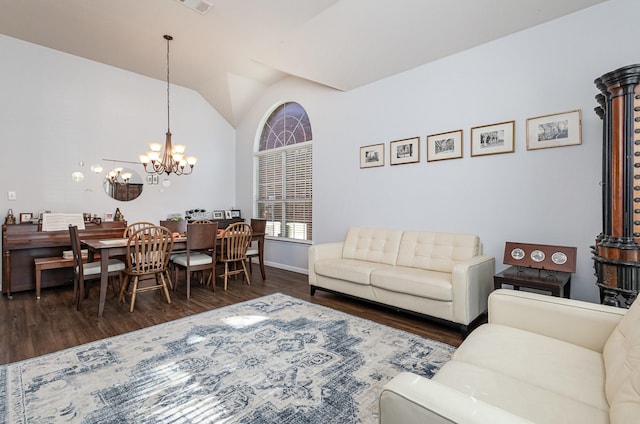 living area featuring visible vents, baseboards, lofted ceiling, wood finished floors, and a notable chandelier