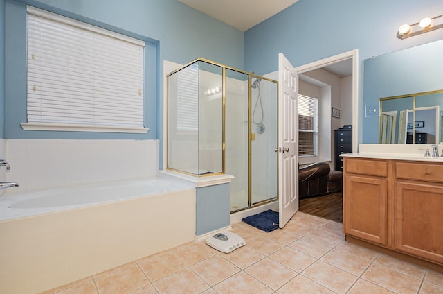 bathroom featuring tile patterned flooring, a shower stall, a bath, and vanity