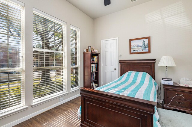 bedroom with dark hardwood / wood-style flooring and ceiling fan