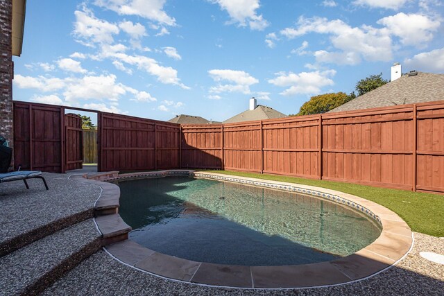 back of property featuring a fenced in pool and a patio