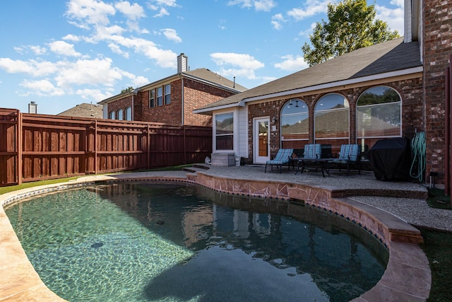 view of swimming pool featuring a fenced in pool, grilling area, a fenced backyard, and a patio area