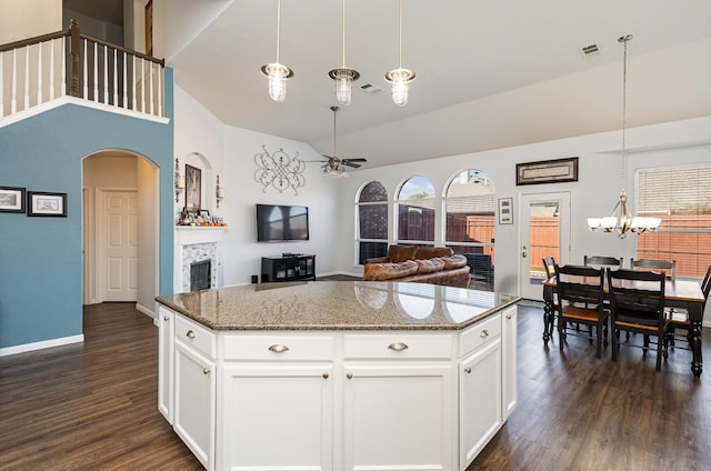 kitchen with white cabinetry, a center island, dark stone countertops, and decorative light fixtures