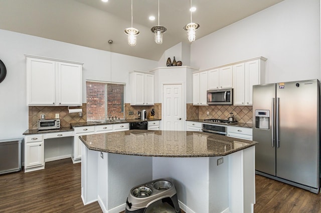 kitchen featuring stainless steel appliances, dark hardwood / wood-style flooring, hanging light fixtures, and white cabinets