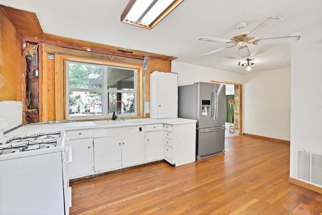 kitchen featuring light hardwood / wood-style flooring, white gas range oven, stainless steel fridge with ice dispenser, white cabinets, and ceiling fan