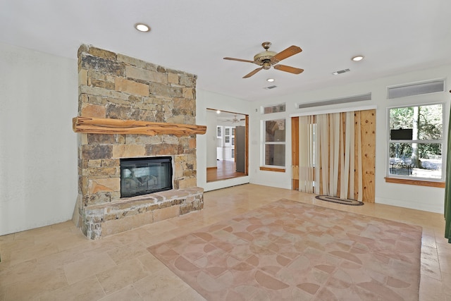 unfurnished living room with ceiling fan and a fireplace