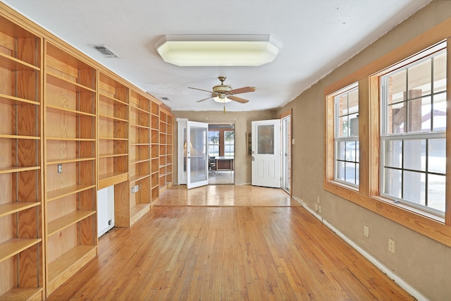 foyer entrance featuring ceiling fan, a wealth of natural light, and light wood-type flooring