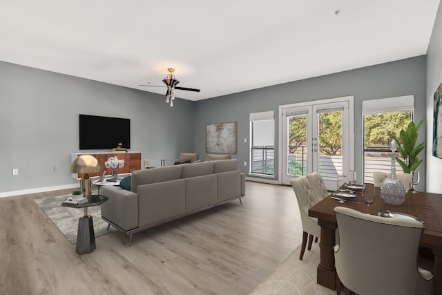 living room with ceiling fan, french doors, and light hardwood / wood-style floors