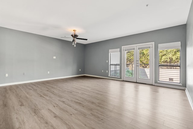 unfurnished room with ceiling fan, light wood-type flooring, and french doors