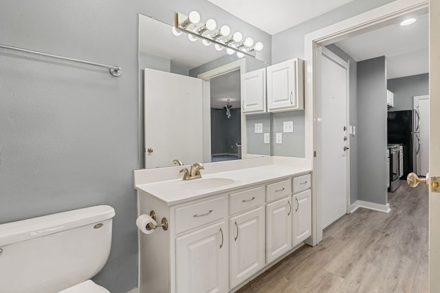 bathroom featuring hardwood / wood-style floors, vanity, and toilet