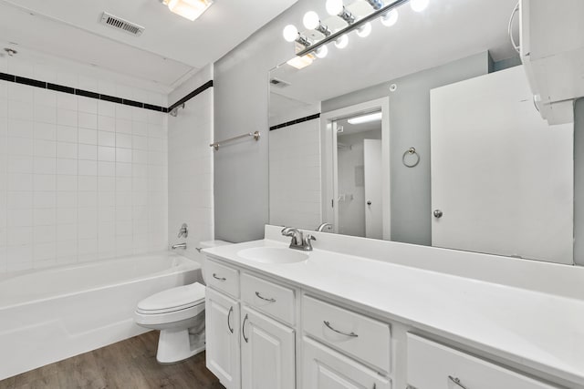 full bathroom with hardwood / wood-style floors, vanity, toilet, and tiled shower / bath combo