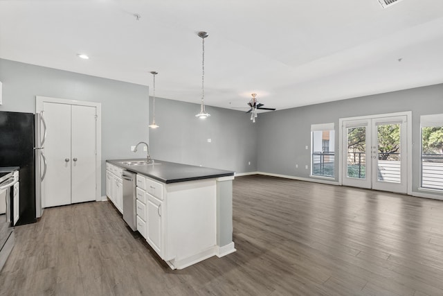 kitchen with stainless steel appliances, white cabinets, decorative light fixtures, sink, and dark hardwood / wood-style floors