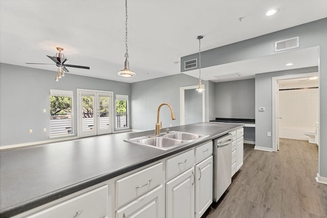 kitchen with white cabinetry, sink, dishwasher, decorative light fixtures, and hardwood / wood-style flooring