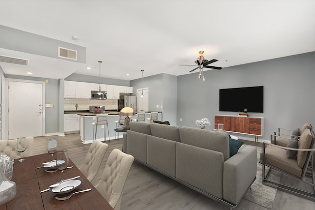 living room with ceiling fan and hardwood / wood-style floors