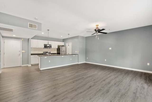 kitchen featuring pendant lighting, hardwood / wood-style floors, ceiling fan, appliances with stainless steel finishes, and white cabinetry