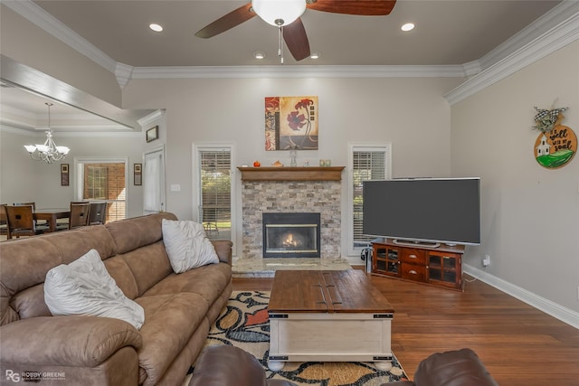 living room featuring crown molding, ceiling fan, wood-type flooring, and a fireplace