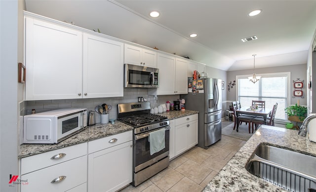 kitchen with tasteful backsplash, appliances with stainless steel finishes, sink, and white cabinets