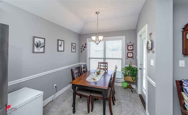 dining area featuring a notable chandelier and vaulted ceiling