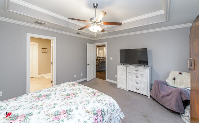 carpeted bedroom featuring ornamental molding, a tray ceiling, and ceiling fan