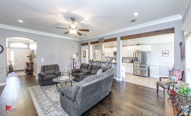 living room featuring crown molding, wood-type flooring, and ceiling fan