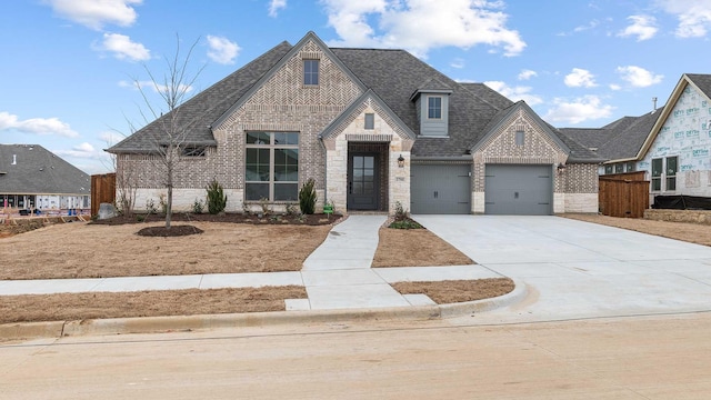 view of front facade featuring driveway, a garage, a shingled roof, stone siding, and brick siding