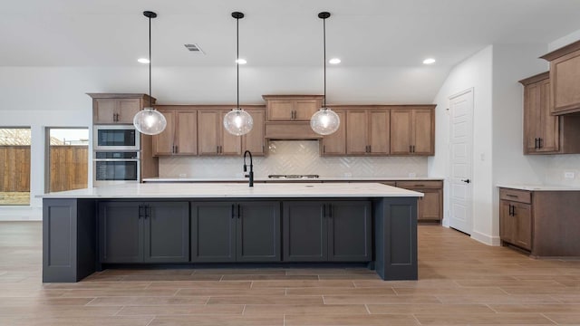 kitchen with visible vents, stainless steel appliances, decorative backsplash, and wood finish floors