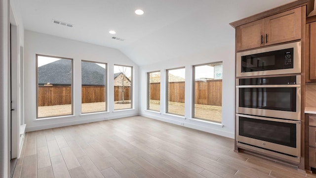 unfurnished sunroom featuring lofted ceiling and visible vents