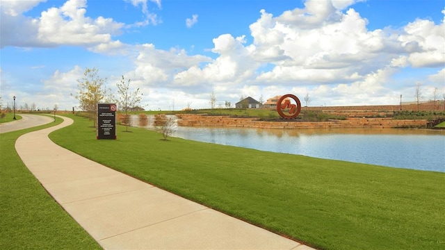 view of community with a yard and a water view