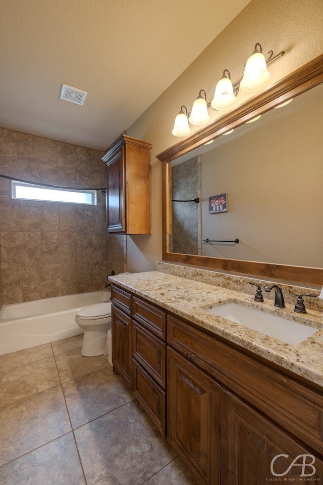 full bathroom featuring tiled shower / bath, vanity, toilet, and tile patterned floors