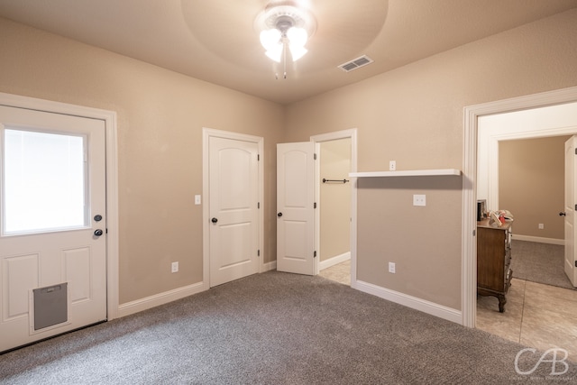 unfurnished room with light colored carpet and ceiling fan