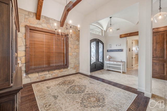 entrance foyer featuring french doors, dark wood-type flooring, and vaulted ceiling with beams