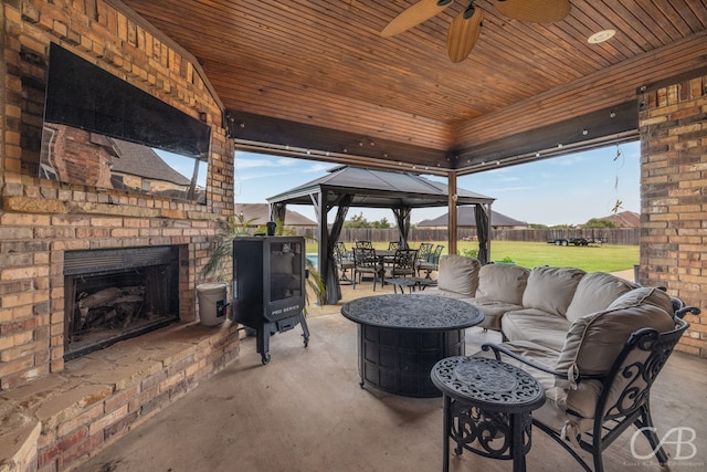 view of patio with a gazebo and an outdoor living space with a fireplace