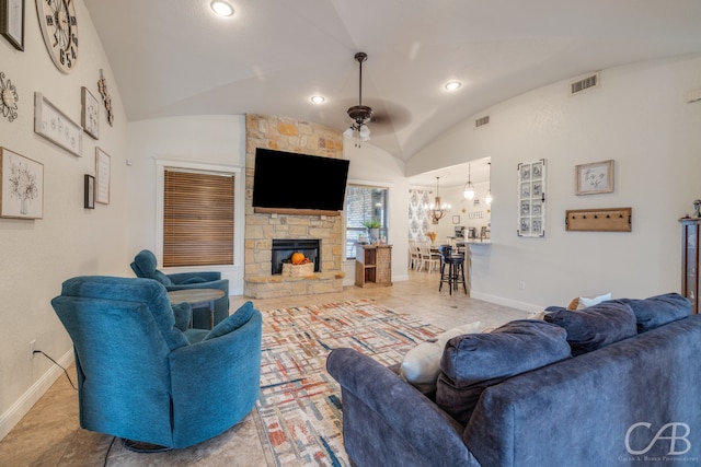 living room featuring lofted ceiling, a fireplace, and ceiling fan with notable chandelier