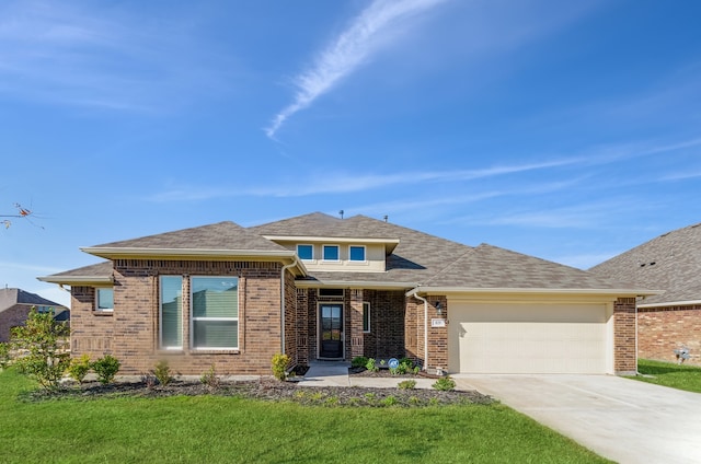 prairie-style home with a garage and a front lawn