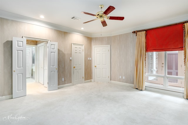 unfurnished bedroom with carpet floors, ornamental molding, and ceiling fan