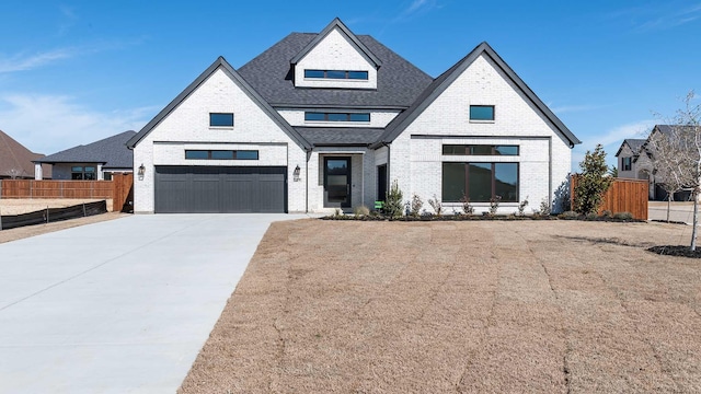 view of front of home with driveway, a shingled roof, fence, and brick siding