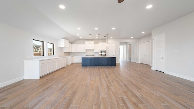 kitchen with recessed lighting, decorative backsplash, light wood-style flooring, and white cabinetry