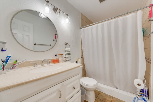 bathroom featuring toilet, walk in shower, vanity, and tile patterned flooring