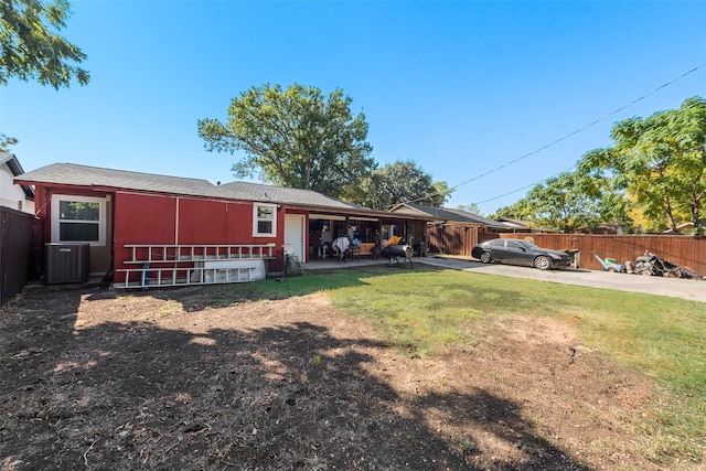 back of house featuring cooling unit and a lawn