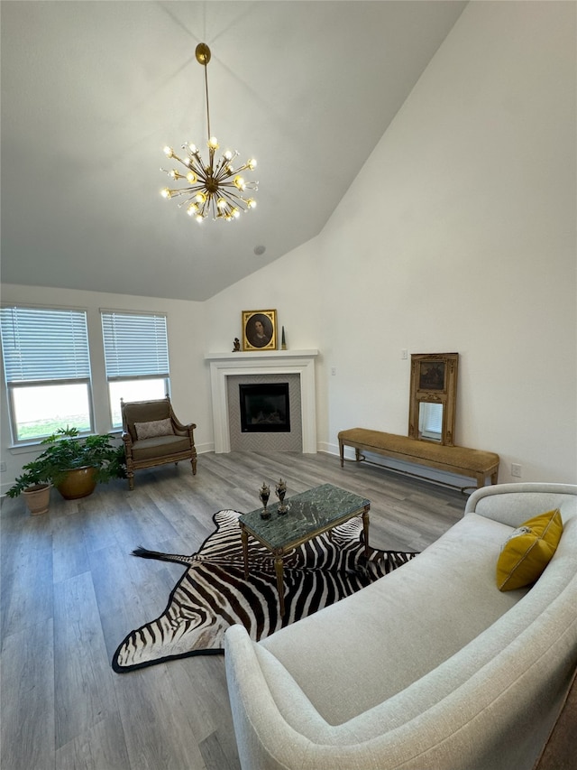 living room with high vaulted ceiling, hardwood / wood-style flooring, and an inviting chandelier