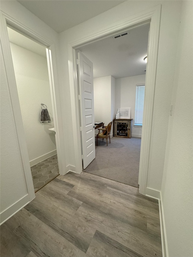 corridor with hardwood / wood-style floors