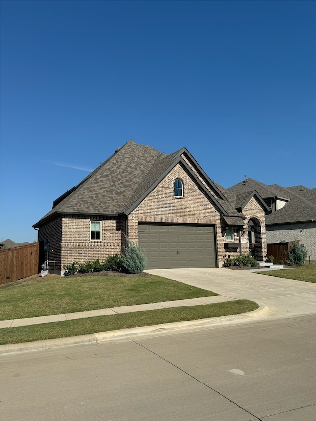 french country inspired facade with a front yard and a garage