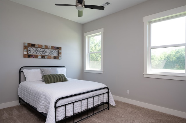 carpeted bedroom with multiple windows and ceiling fan