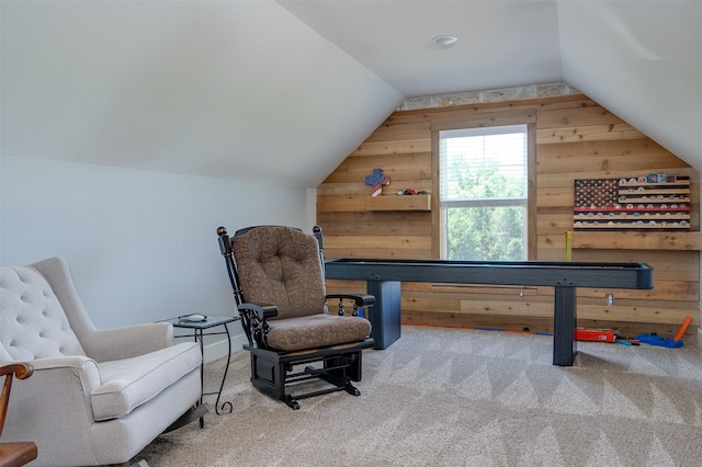 sitting room with lofted ceiling, wooden walls, and carpet