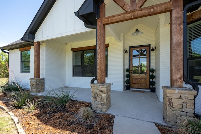 view of exterior entry featuring covered porch